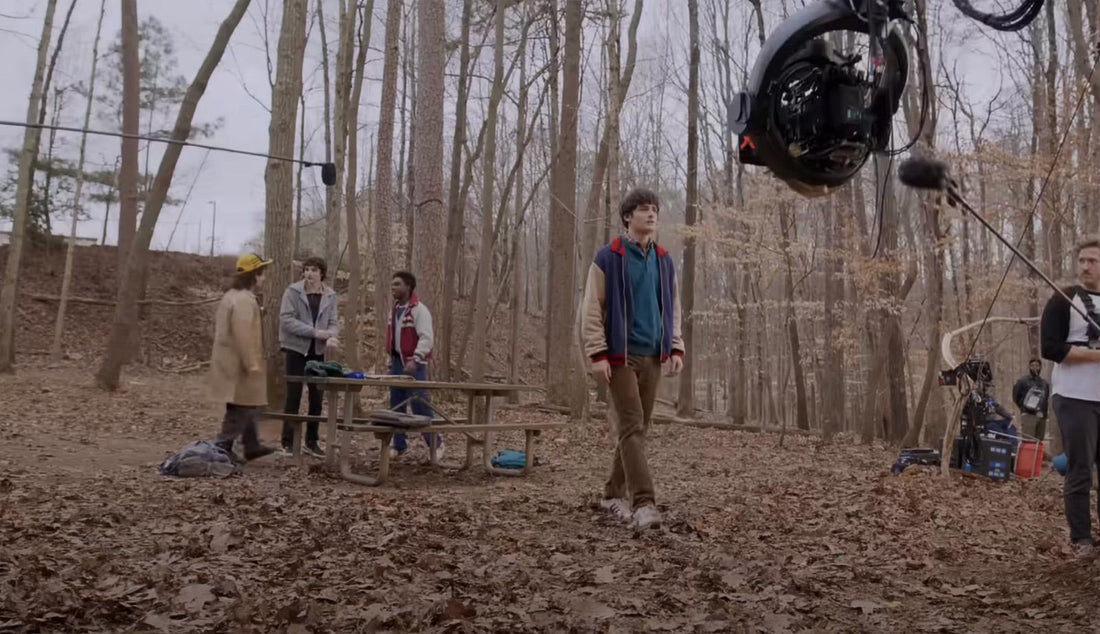 Riprese di Stranger Things nel bosco: la gru della cinepresa e la troupe che fanno il budget di un episodio