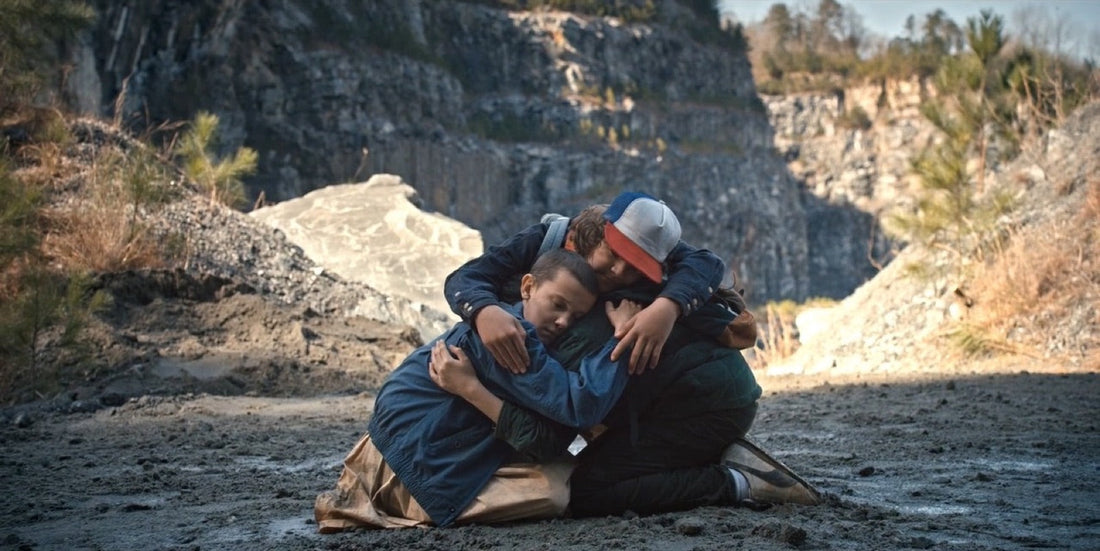 Tre ragazzi inginocchiati e abbracciati in fondo a una cava, Stranger Things stagione 1 episodio 6