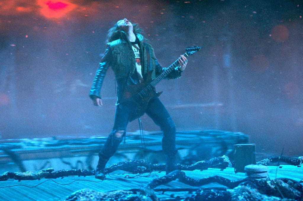 Eddie Munson suona la chitarra, testa all'indietro, sul tetto del Sottosopra
