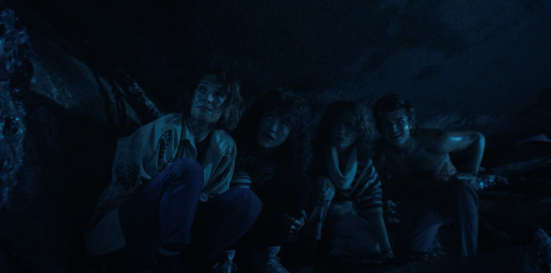 Nancy, Robin, Eddie e Steve, fradici, sotto la roccia dopo il tuffo.