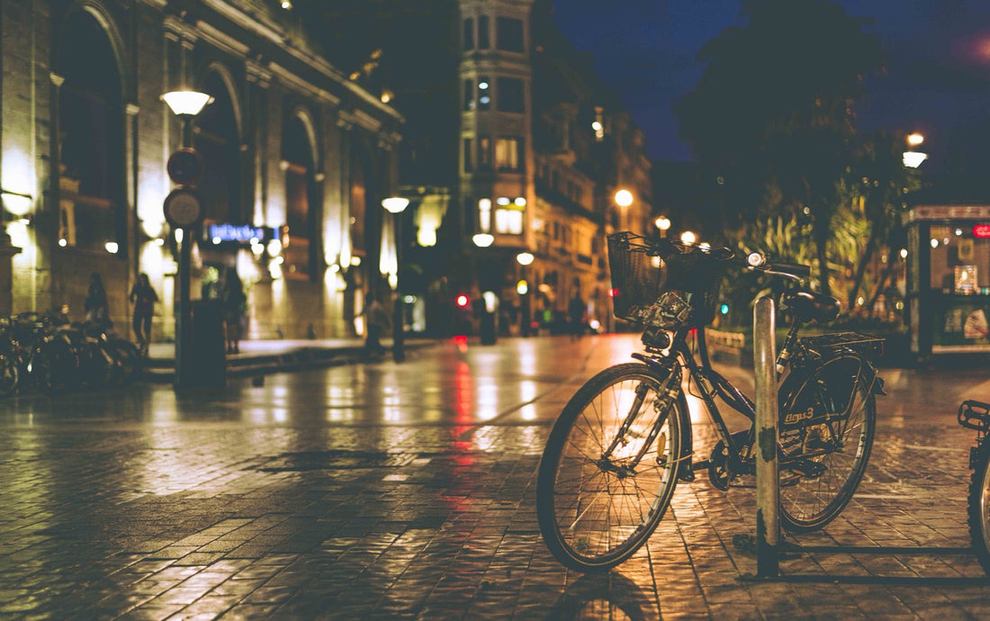 Strada di notte, lampioni e bicicletta, luce arancione sull'asfalto