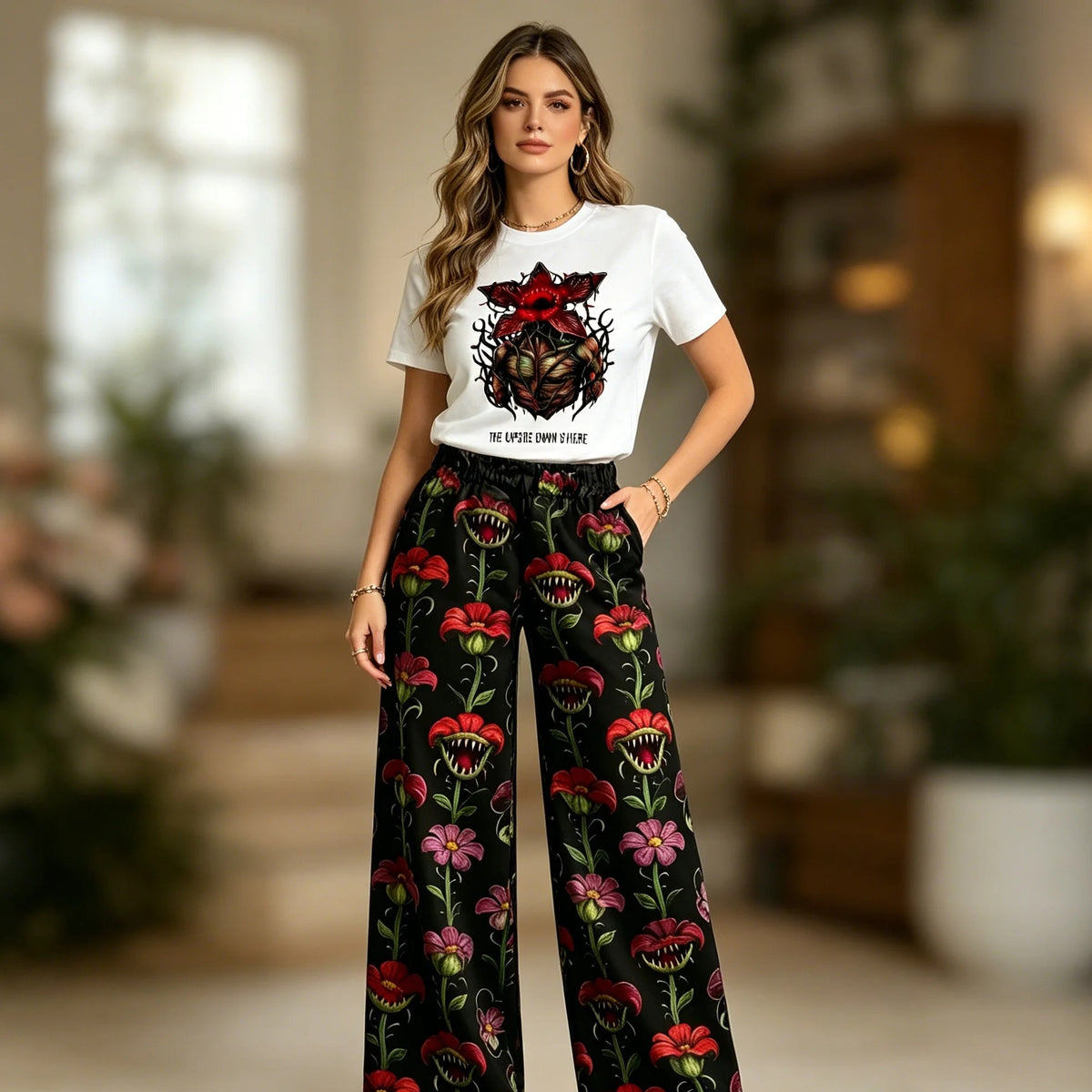 Donna che indossa il pigiama Stranger Things con t-shirt bianca Demogorgone e pantaloni larghi a fiori